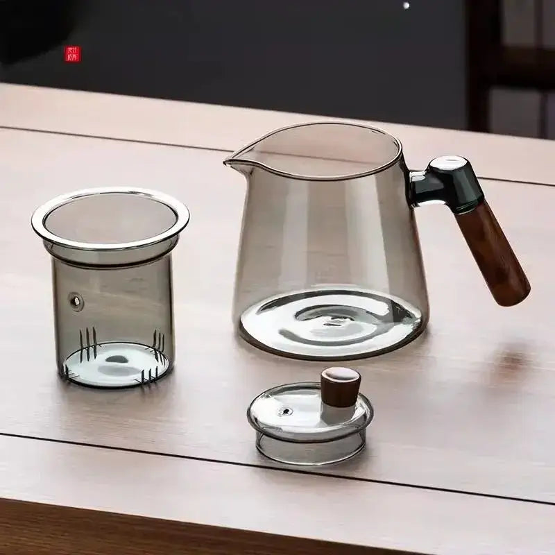 Decorbites glass tea set featuring a transparent teapot with wooden handle and metal accents on a retro glass tray