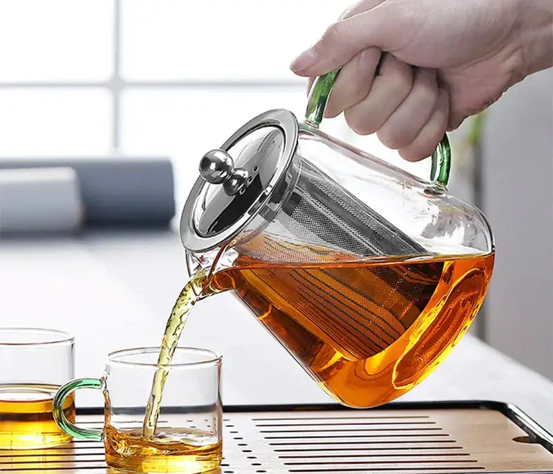 Clear glass teapot with green handles and stainless steel lid featuring mesh infuser strainer by decorbites glass teapot