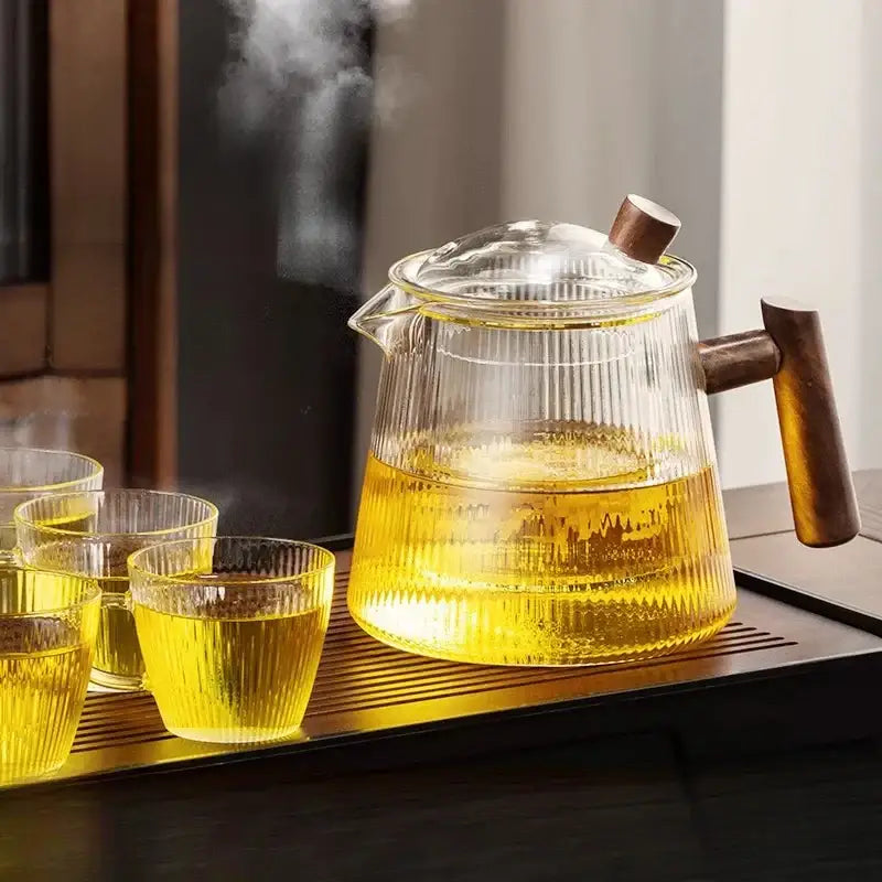 Decorbites glass teapot 900ml with wooden handle filled with steaming golden tea for puer kung fu tea brewing