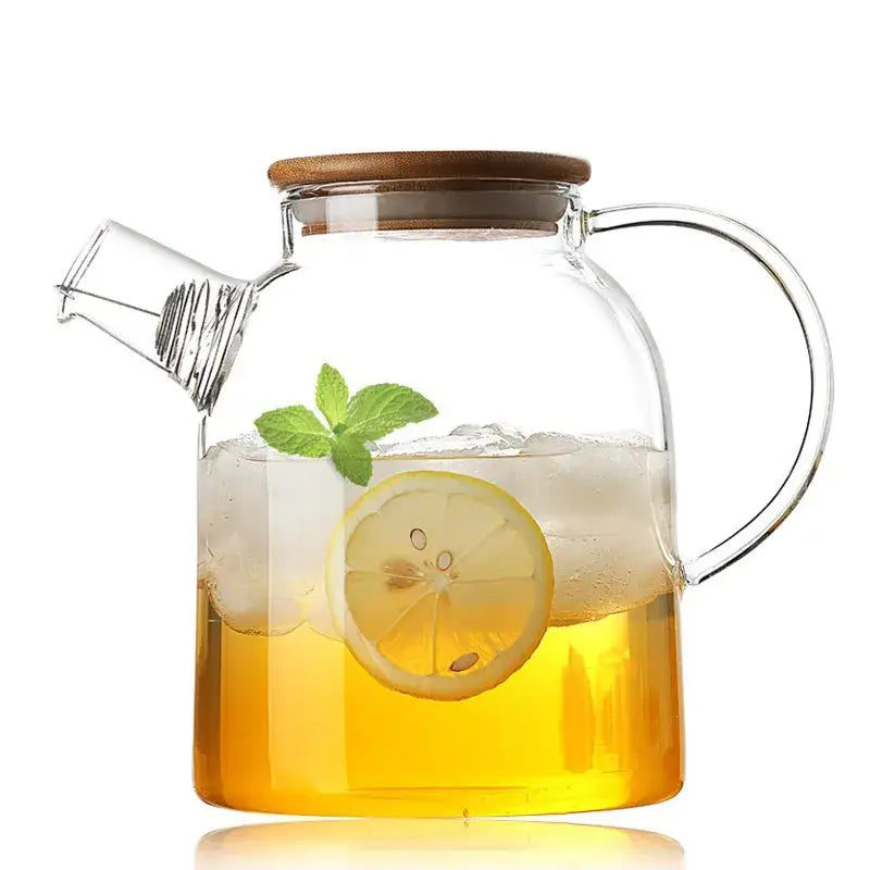 Clear glass teapot with wooden lid filled with iced lemon tea and mint leaves from decorbites glass teapot cold collection