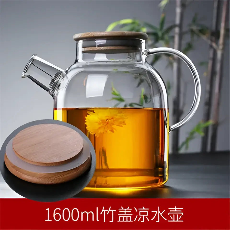 Decorbites glass teapot with bamboo lid and handle filled with golden tea and floating yellow flowers for cold water use