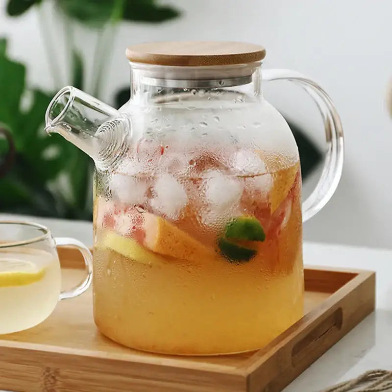 Clear glass decorbites glass teapot with wooden lid and handle filled with iced fruit beverage for cold water use