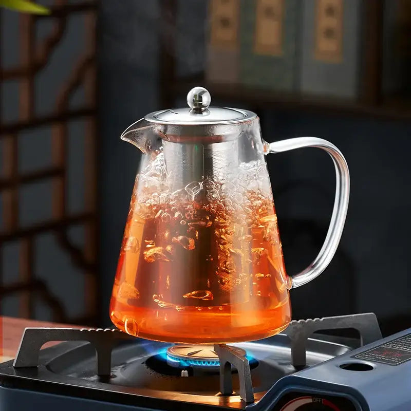 Decorbites glass teapot with stainless steel lid and handle filled with boiling orange puer tea for heat resistant use