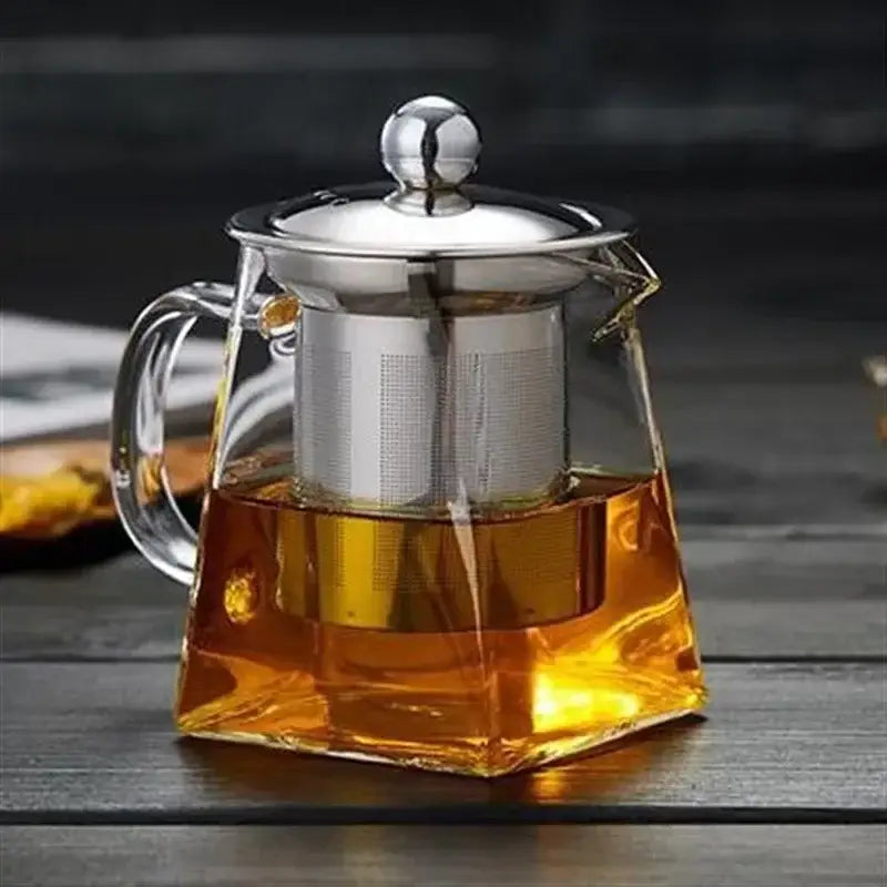 Clear glass teapot infuser with silver stainless steel lid and built-in filter holding amber tea by decorbites glass teapot