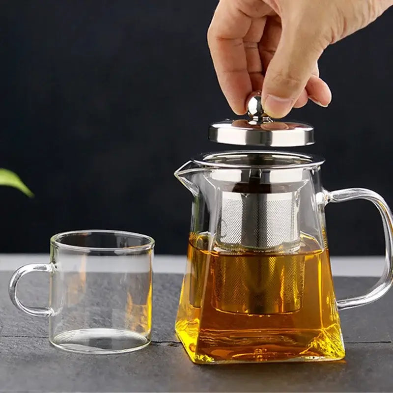 Decorbites glass teapot infuser made of clear glass with stainless steel lid and built-in filter filled with golden tea