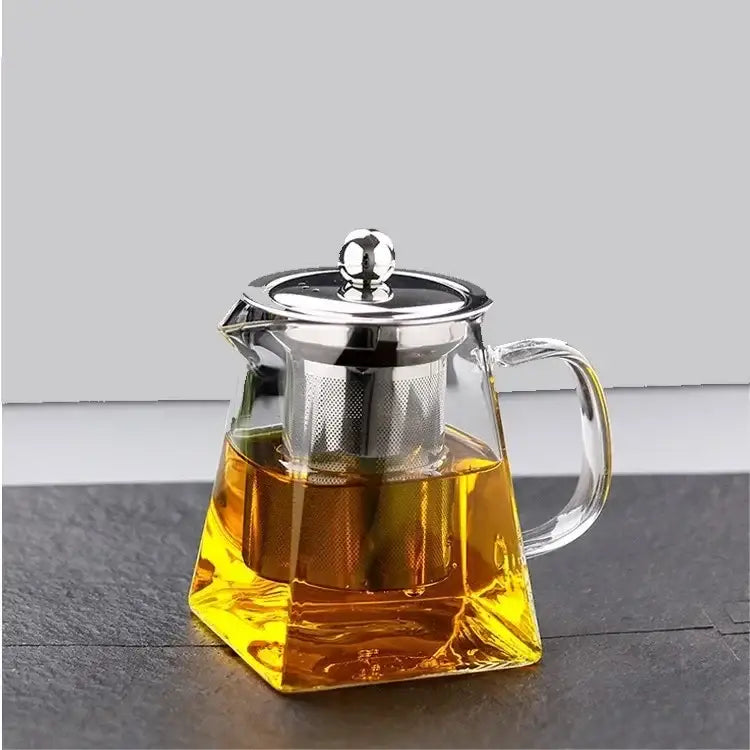Clear glass teapot infuser with silver lid filled with golden tea from decorbites glass teapot tea set