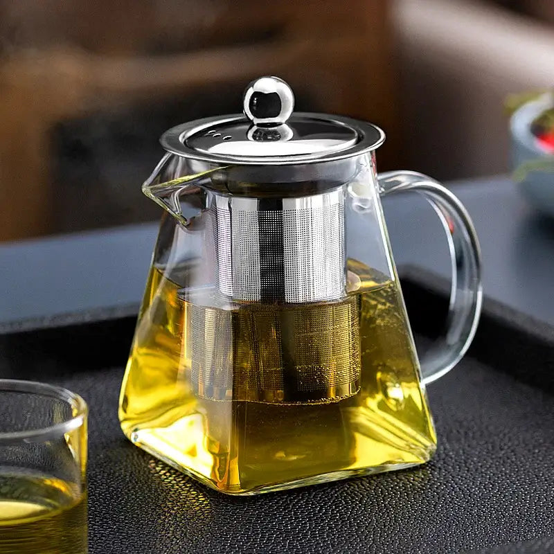 Clear glass teapot with stainless steel infuser and lid filled with golden tea in decorbites glass teapot kungfu tea set