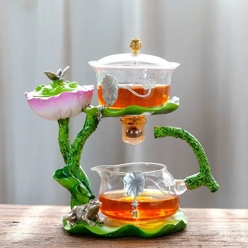 Decorbites glass teapot with lotus design featuring translucent green and pink ceramics and silver lazy tea infuser accents