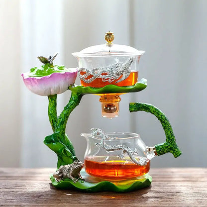 Decorbites glass teapot with lotus design and silver dragons featuring an ornate golden knob and lazy tea infuser