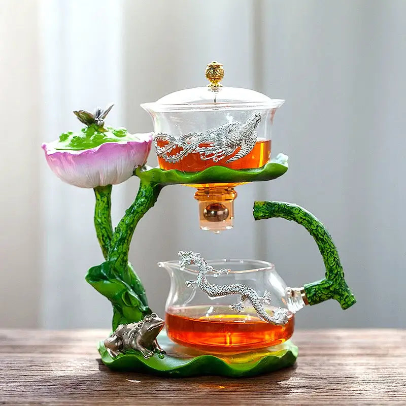 Decorbites glass teapot with lotus design and silver dragons featuring an ornate golden knob and lazy tea infuser