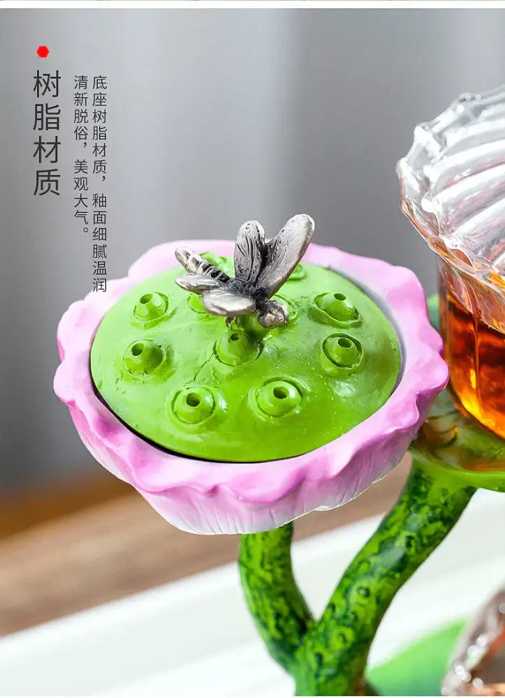 Decorbites™ glass teapot with a pink and green lotus-shaped lazy tea infuser featuring a silver butterfly lid