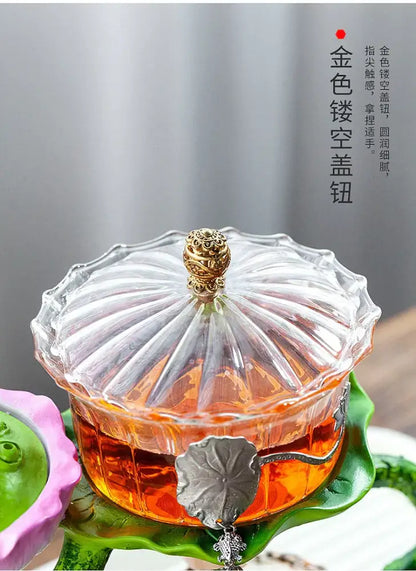 Clear glass DecorBites™ glass teapot with golden ornate lid and silver leaf handle featuring a lazy tea infuser