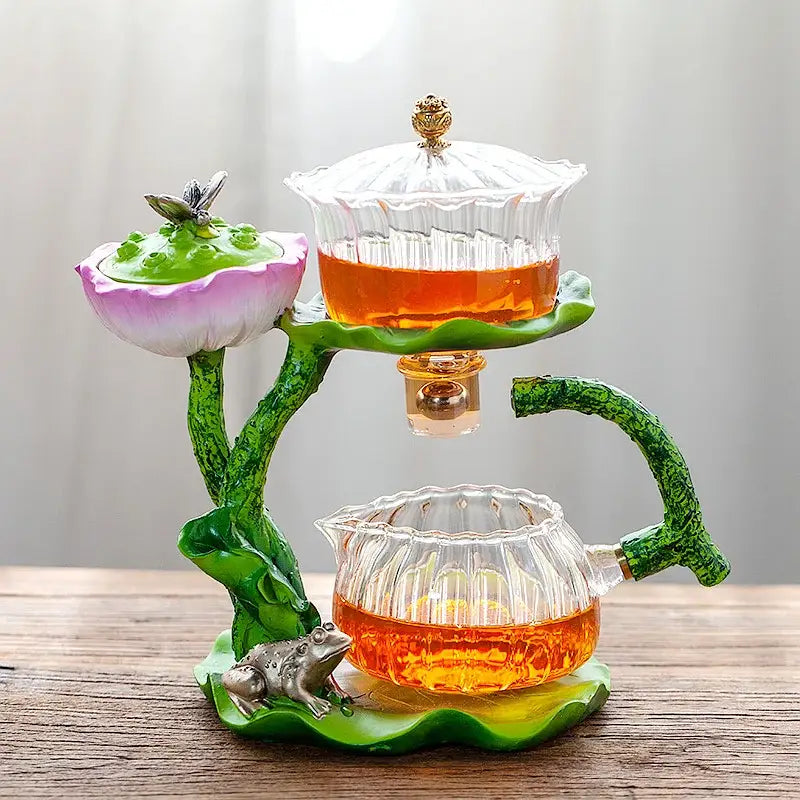 Decorbites glass teapot lazy tea infuser with green lotus base and clear ribbed glass containers filled with amber tea