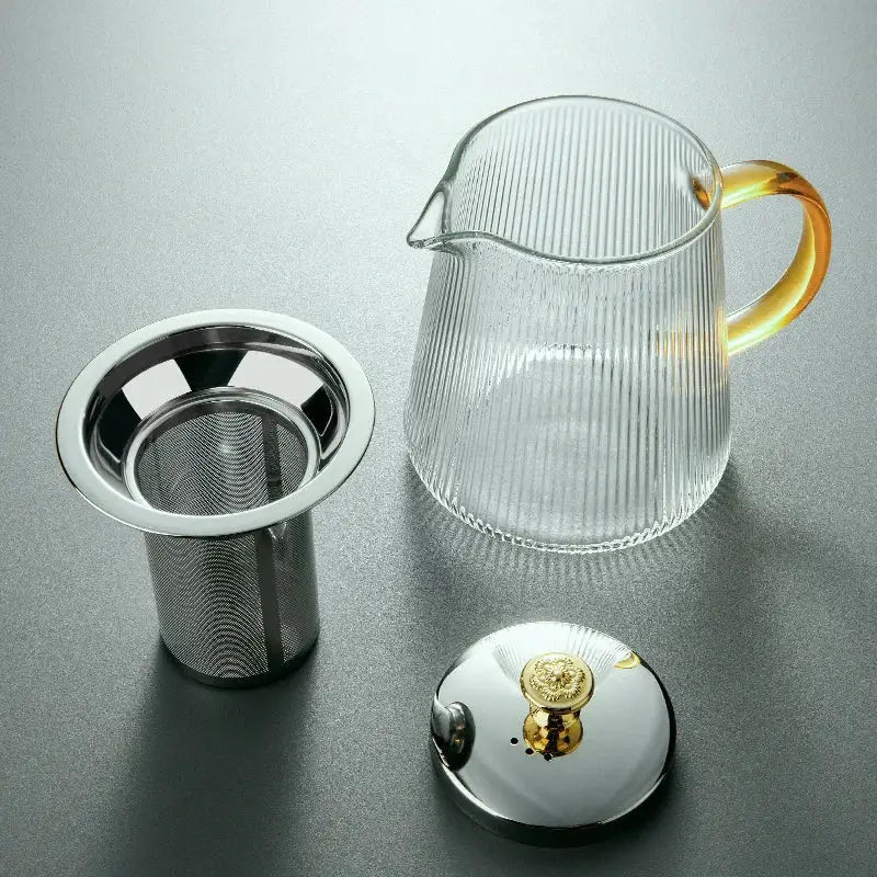 Clear glass teapot puer by decorbites with vertical ribbed texture, amber handle, stainless steel infuser, and matching lid