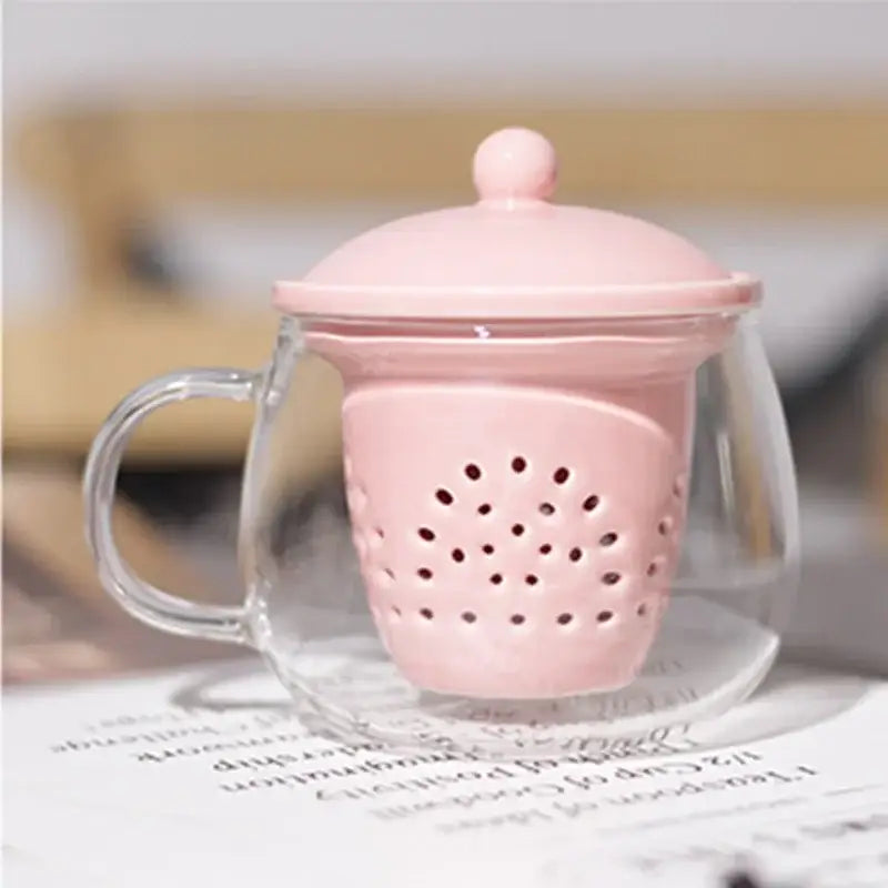Pink ceramic filter with matching lid inside clear glass mug in DecorBites glass teapot set for puer tea infusion
