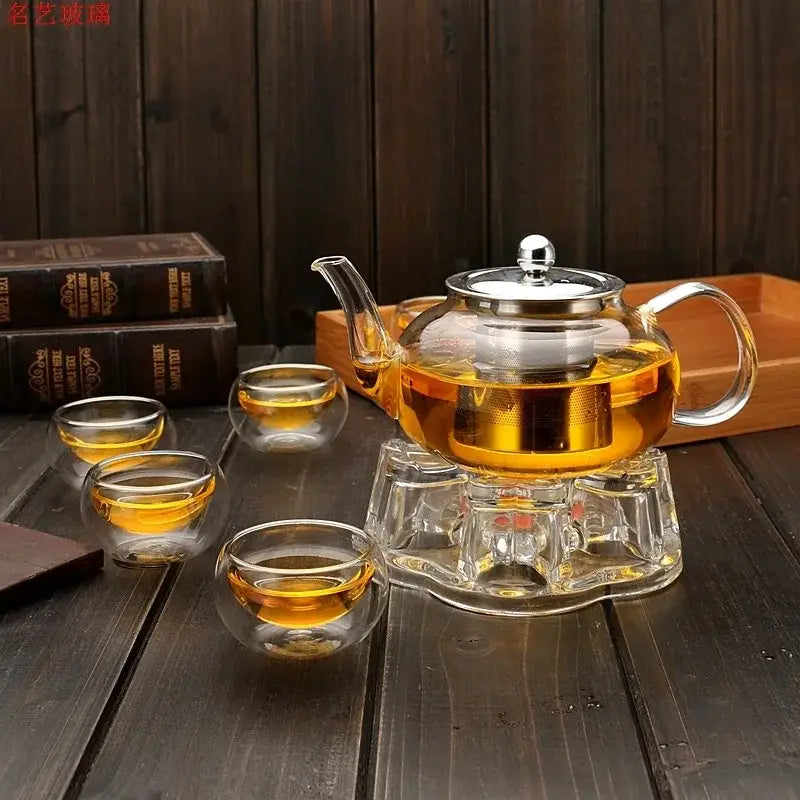 Clear glass DecorBites glass teapot set with stainless steel lid and handle filled with golden tea for heat resistance