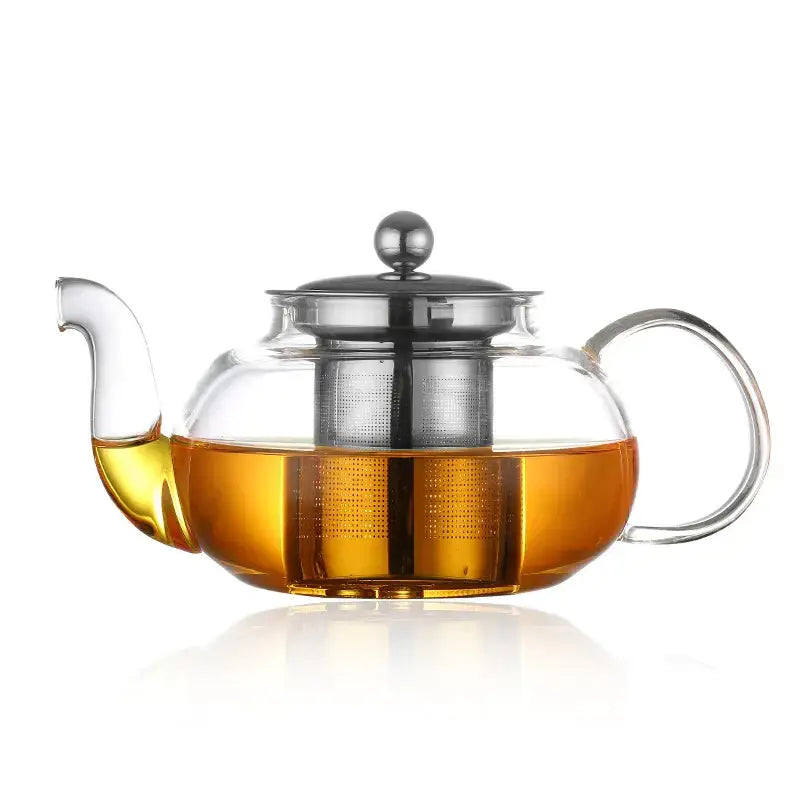 Clear glass teapot set with stainless steel infuser and lid filled with amber tea by decorbites glass teapot