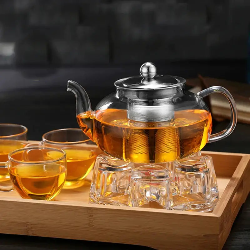 Clear glass DecorBites glass teapot set with stainless steel lid and built-in strainer filled with amber tea
