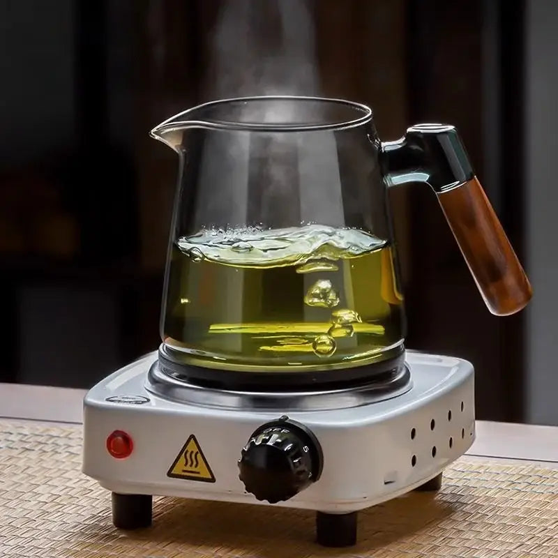 DecorBites glass teapot set with clear glass teapot and wooden handle steaming green tea on white electric base