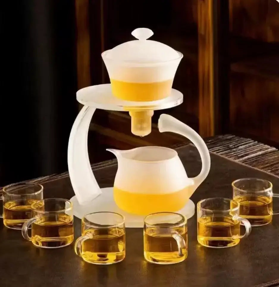 White glass teapot with magnetic drip pot and base featuring a tiered design and covered infuser pot with golden tea