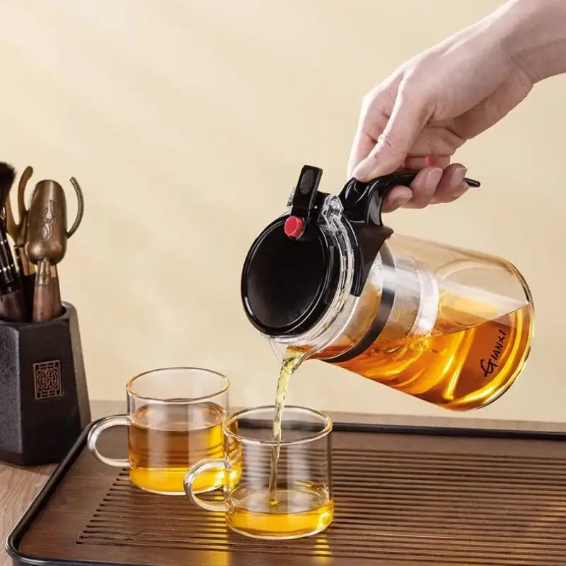 Clear glass DecorBites glass teapot with black lid, handle, and red button for one-button tea brewing filtration