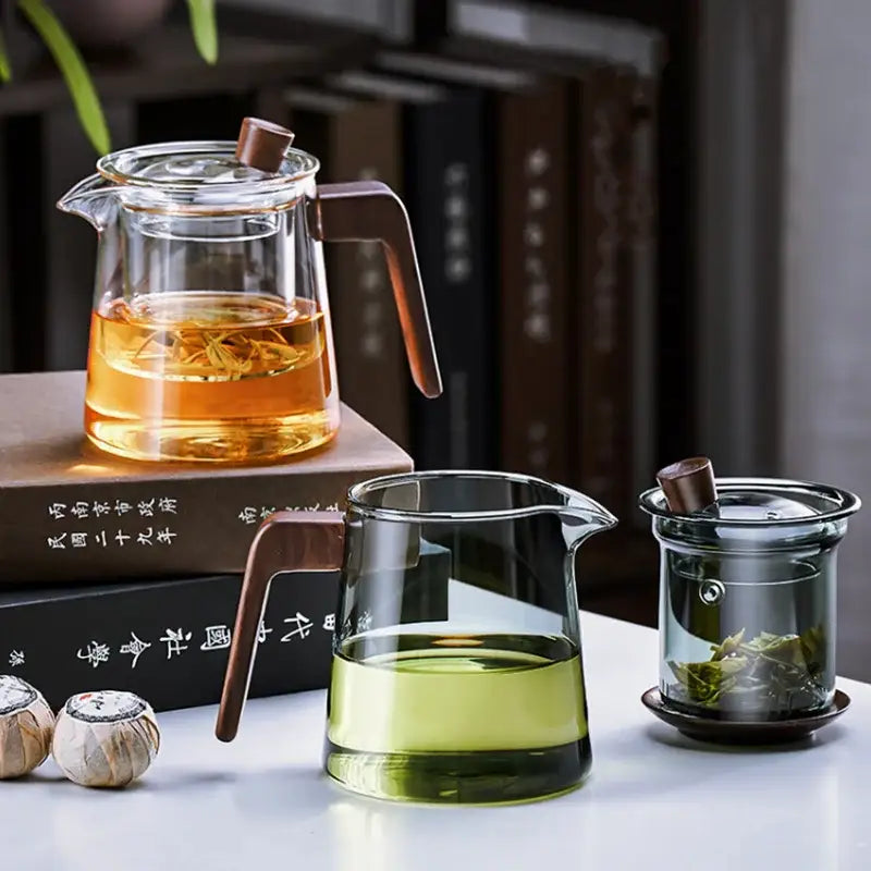 Clear glass teapot with wood handle and lid knob filled with amber tea decorbites glass teapot for Chinese tea ceremony