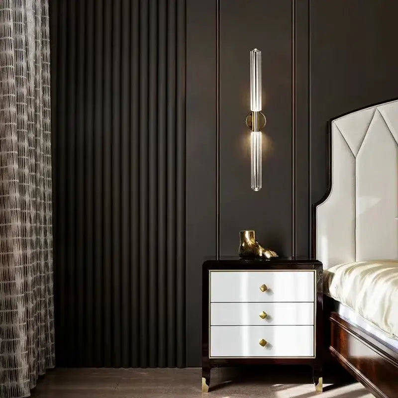 A sleek decorbites glass tubes led wall sconce with clear glass tubes and gold accents for modern luxury spaces