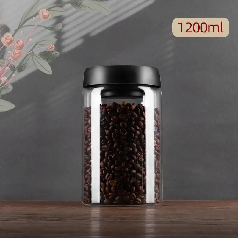 Clear glass decorbites glass vacuum sealed coffee beans canister with black lid holding dark roasted coffee beans