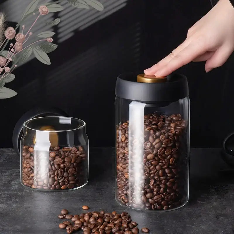 Clear glass vacuum sealed coffee beans storage jar with black lid and gold knob by decorbites glass vacuum