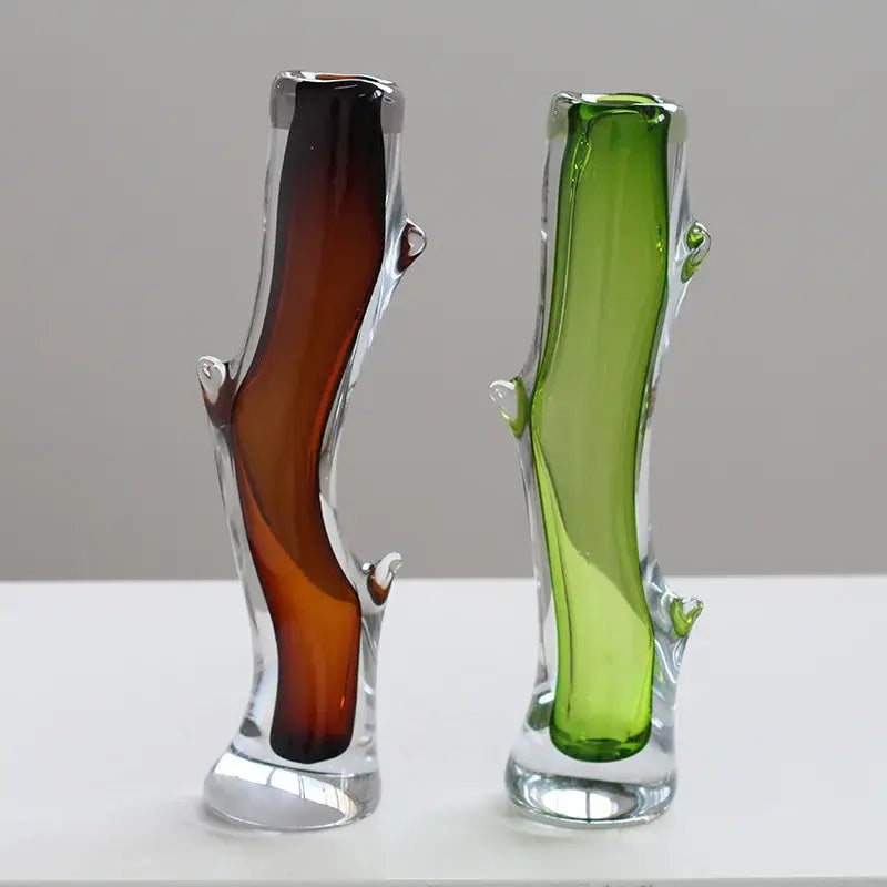 Two translucent decorbites glass vases shaped like tree trunks in amber and green for floral arrangement terrarium