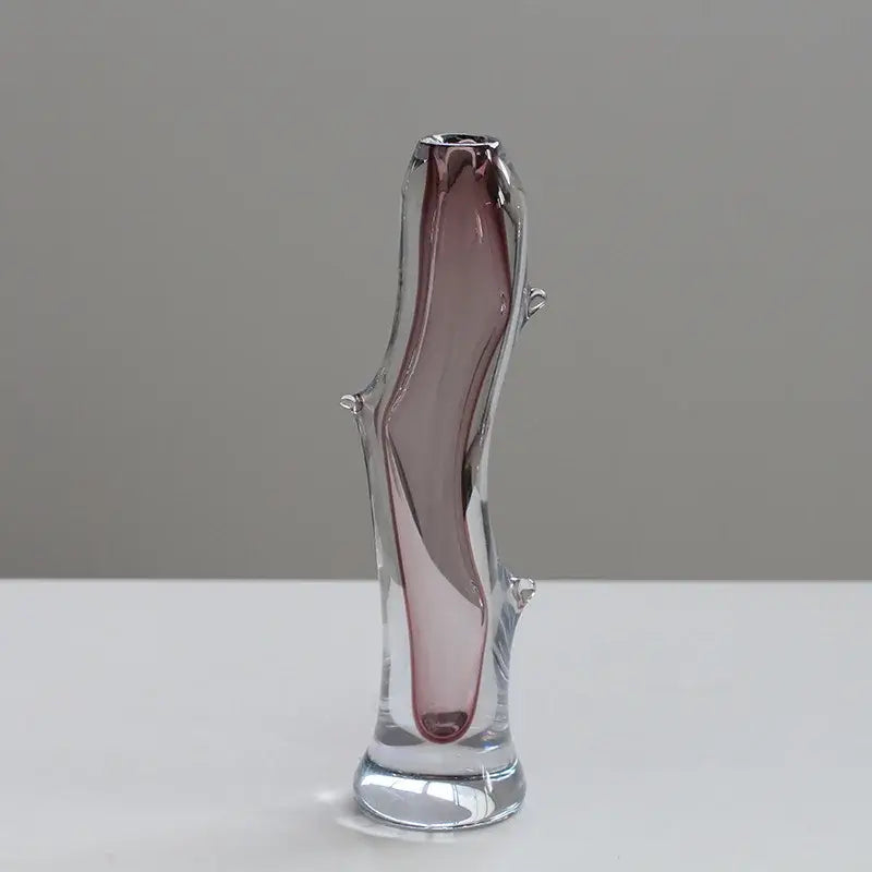 A slender decorbites glass vase with a curved body and pinkish purple hue for floral or terrarium use