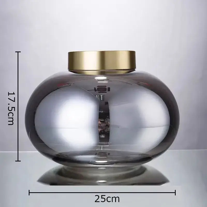 A decorbites glass vase desk decoration with a translucent gray glass body and polished gold-toned metal lid