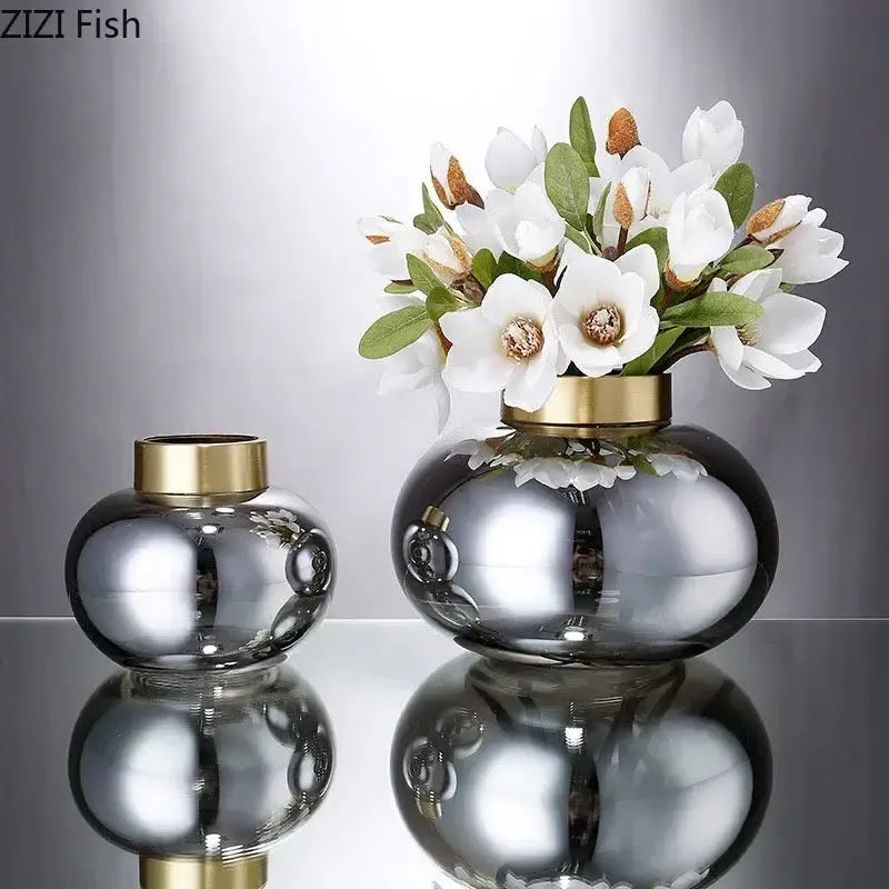 Two sleek round decorbites glass vases with gold-toned rims and reflective surface for modern desk decoration