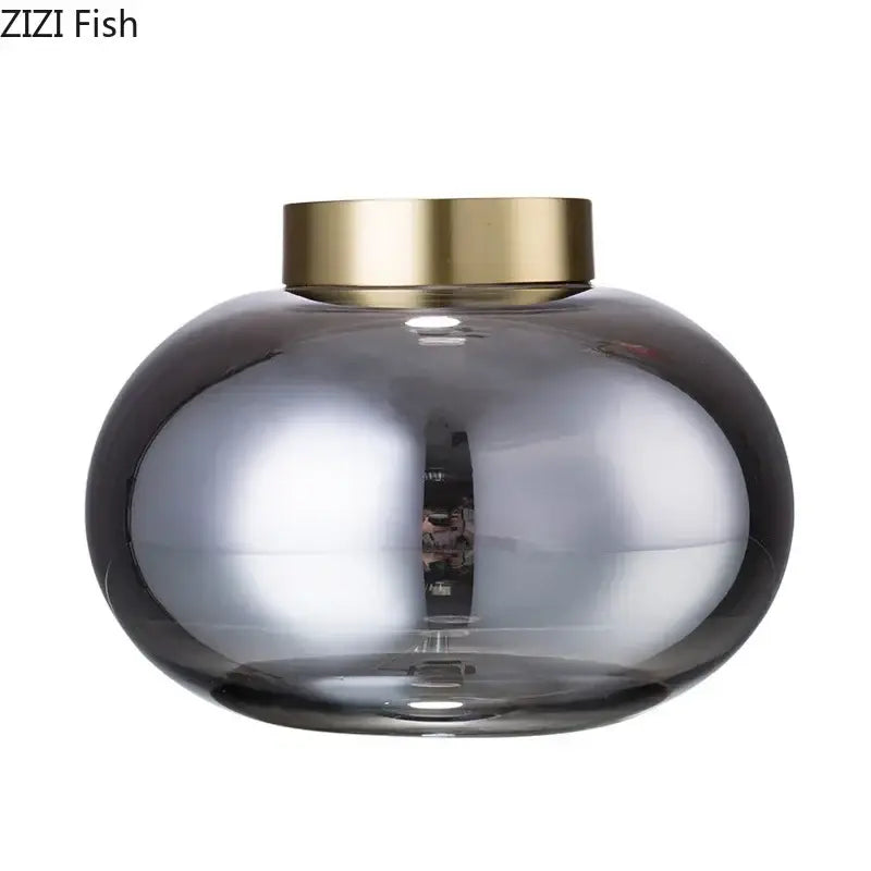 A sleek decorbites glass vase with a rounded glass body and metallic gold lid ideal for glass vase desk decor