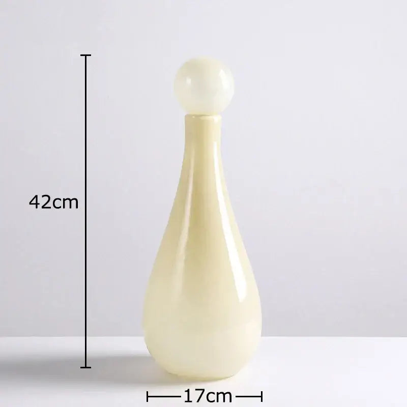 Cream-colored decorbites glass vase with smooth glossy finish and rounded stopper for vase flower arrangement