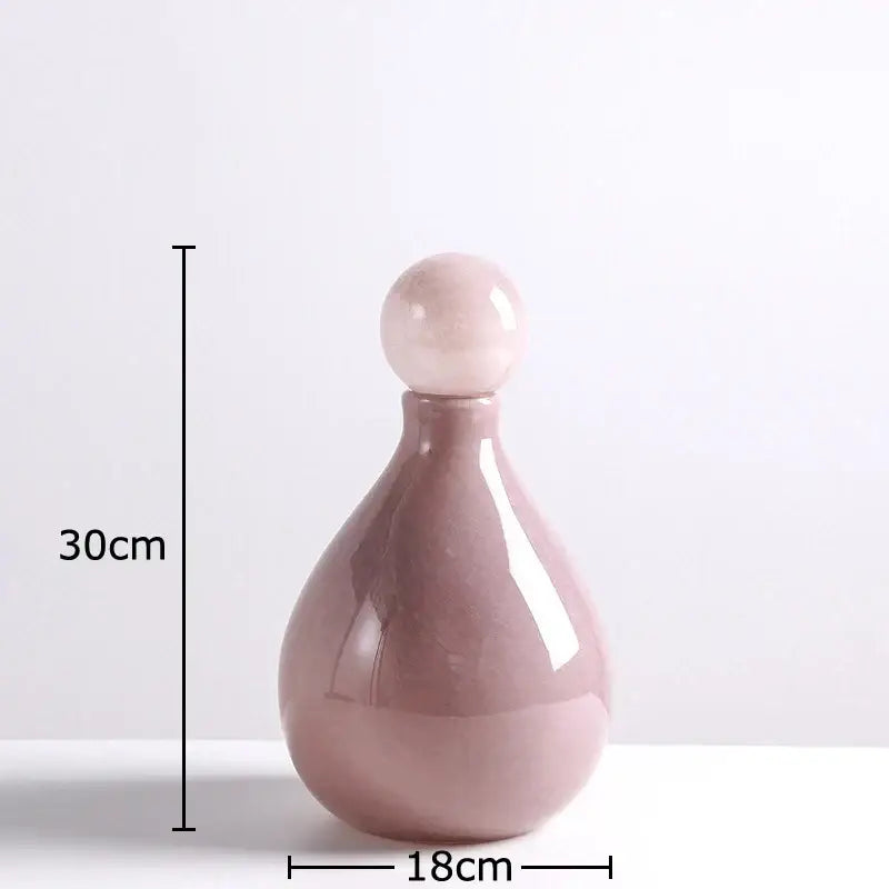 A sleek matte blush pink ceramic decorbites glass vase with a rounded body and stopper for vase flower arrangement