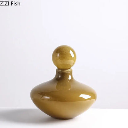 A sleek amber-colored glass vase with a rounded body and spherical stopper for decorbites glass vase flower arrangement
