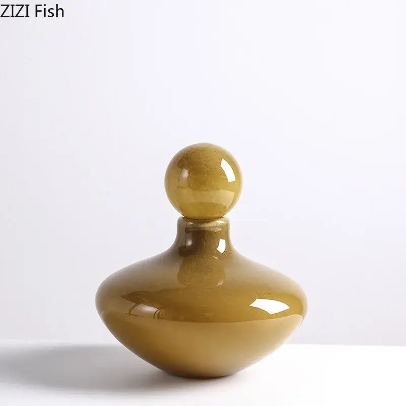 A sleek amber-colored glass vase with a rounded body and spherical stopper for decorbites glass vase flower arrangement