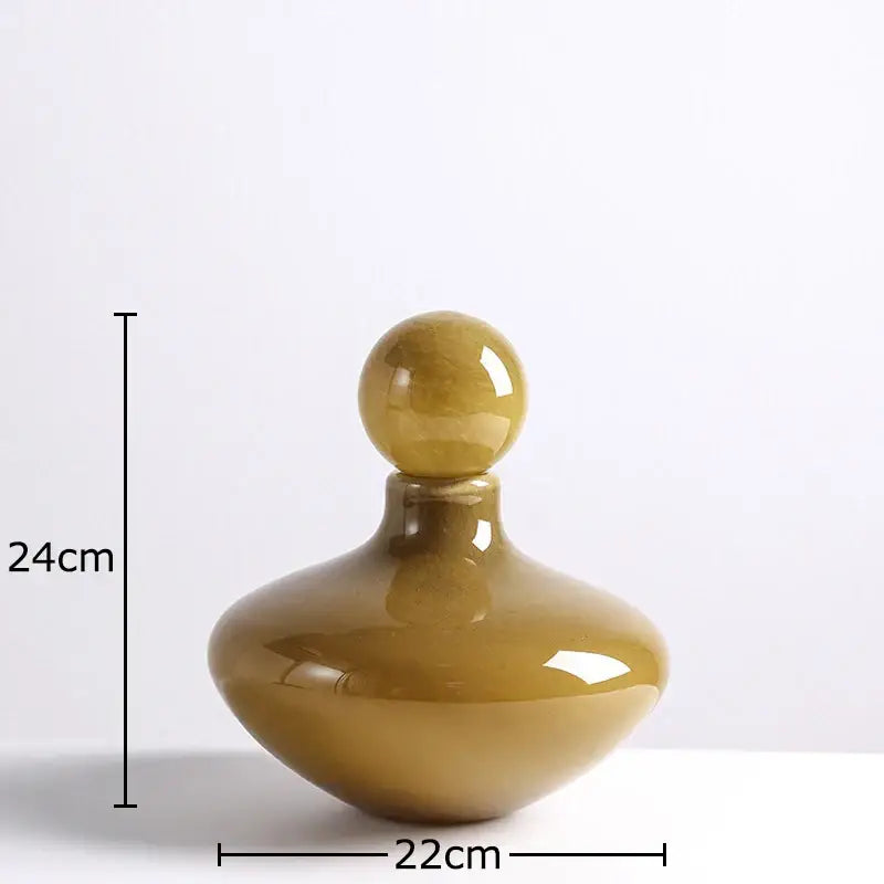 A glossy amber glass vase decanter with a rounded body and spherical stopper for decorbites glass vase flower arrangement