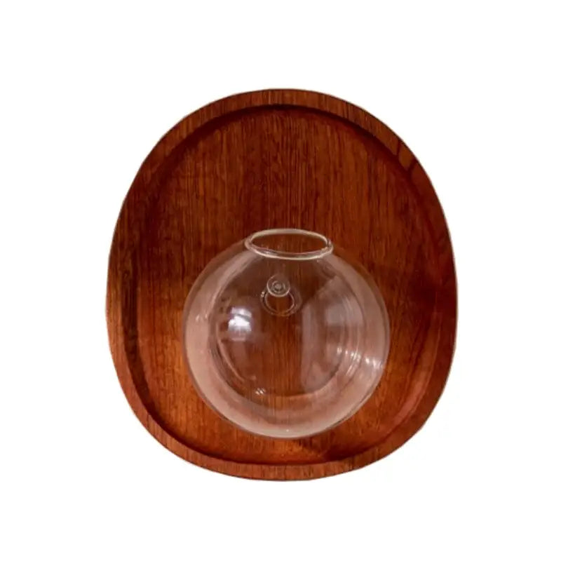 Clear glass decorbites glass vase with a narrow neck resting on a round wooden base for vase flowerpot wall décor