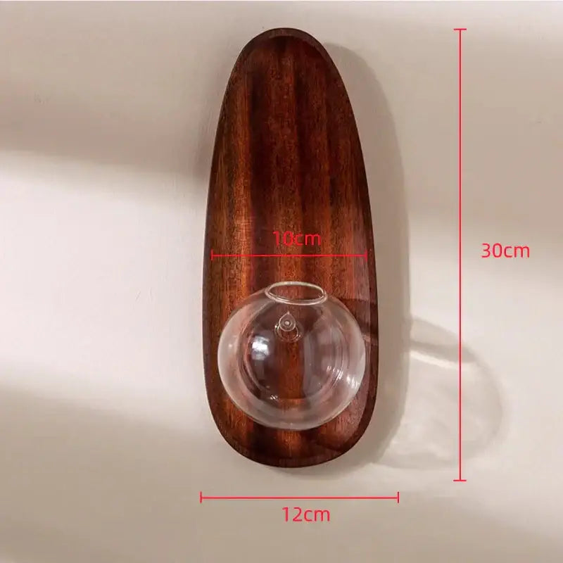 A sleek dark brown wooden decorbites glass vase wall flowerpot with an integrated clear glass sphere for plants