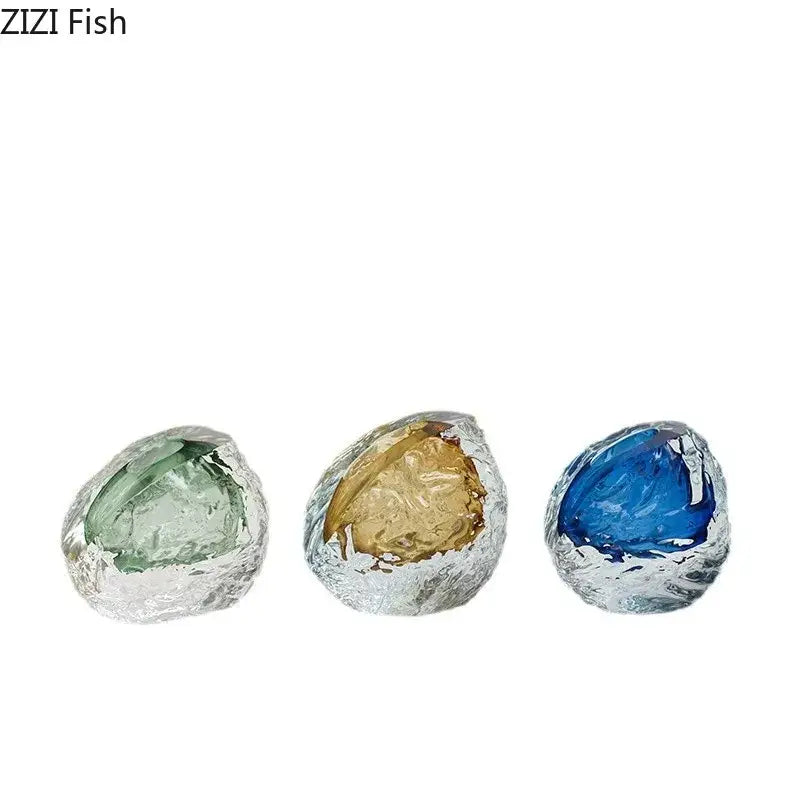 Three translucent glass fish sculptures in green gold and blue encased in silver foil with decorbites glass wrinkle design