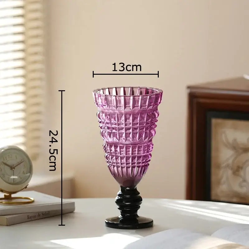 A tall translucent purple decorbites glass vase with black base and geometric cut patterns for room decor and flowers