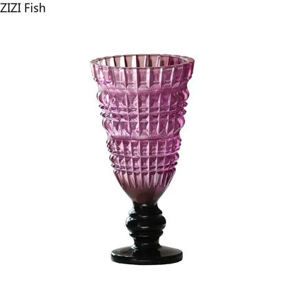 A tall faceted purple decorbites glass vase with black base and stem for hydroponics and flower arrangement