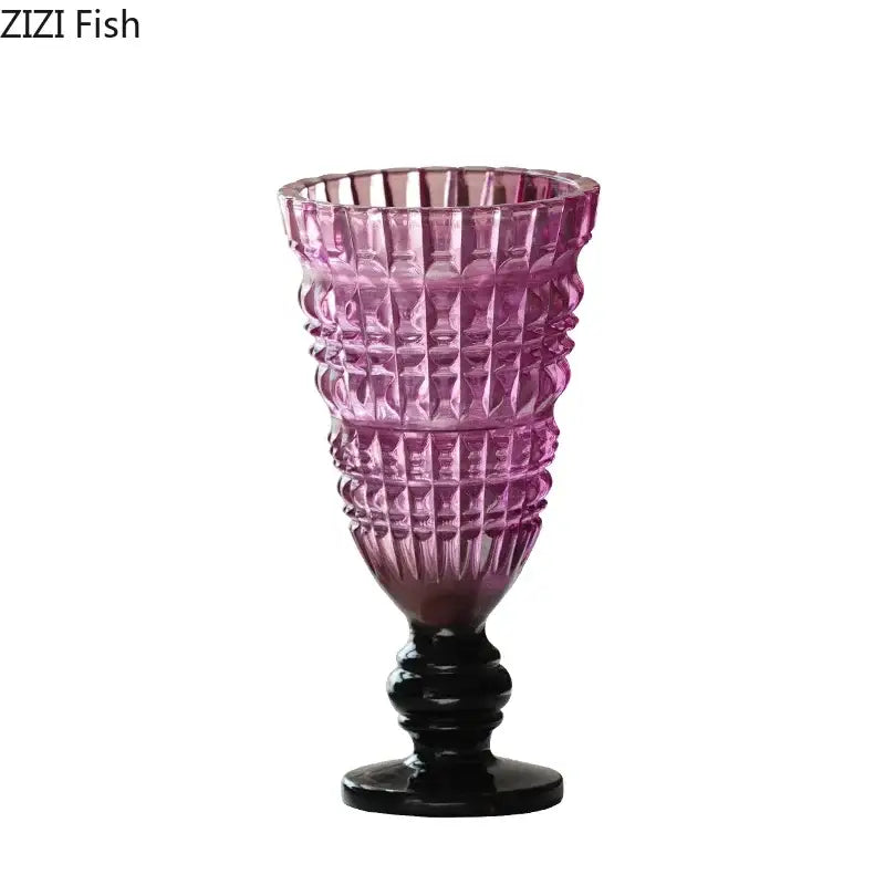 A tall faceted purple decorbites glass vase with black base and stem for hydroponics and flower arrangement