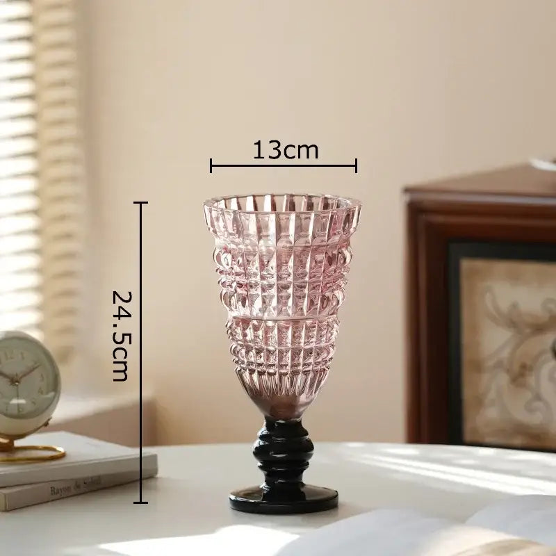 A tall slender pink decorbites glass vase with black base and geometric cut patterns for hydroponics plant decor
