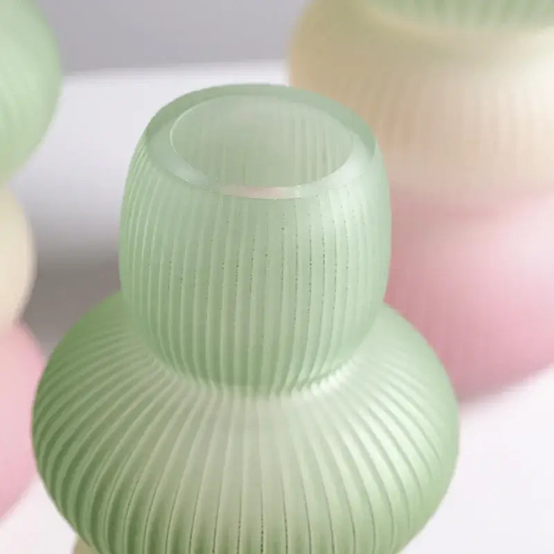 A translucent mint-green decorbites glass vase with vertical ribbed texture and geometric gradient two-tiered shape