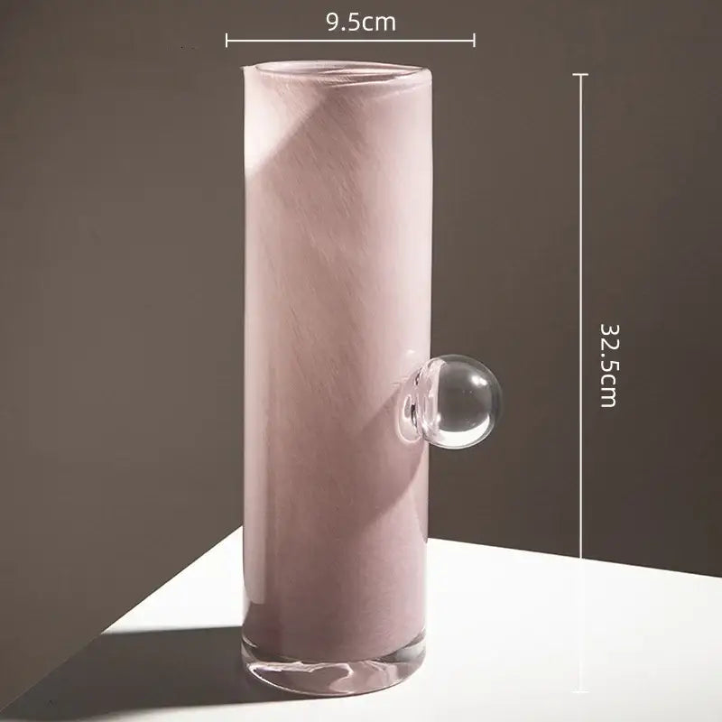 A tall translucent pink decorbites glass vase with a clear geometric sphere accent for flowers and accessories