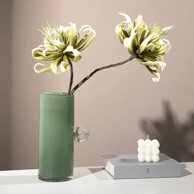 A sleek matte sage green decorbites glass vase geometric sphere with a clear spherical handle for flowers and accessories