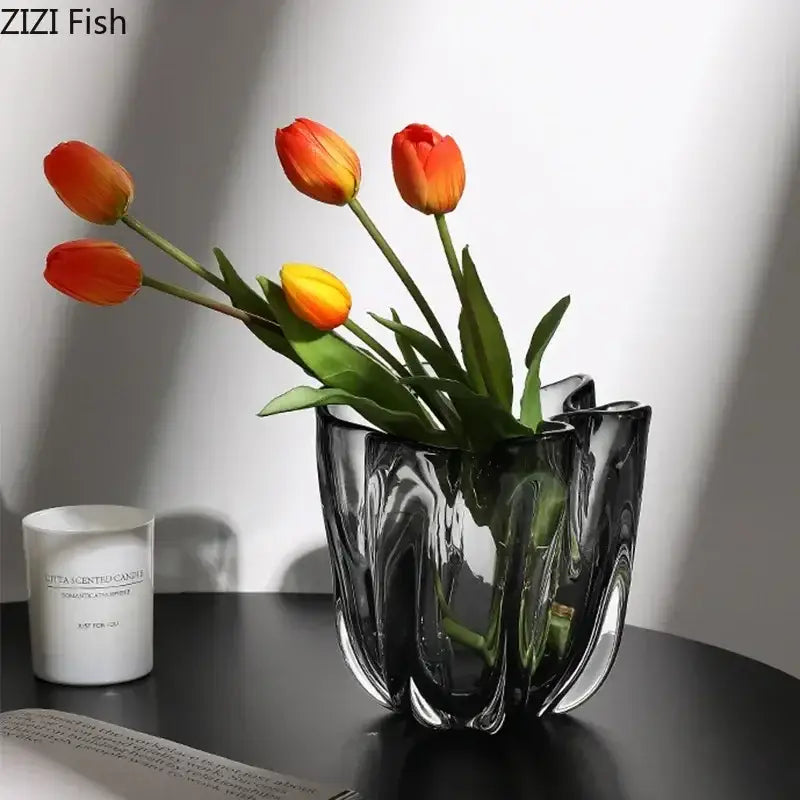 A sleek dark-tinted glass vase with wavy design holding orange and yellow tulips for decorbites glass vase hydroponics desk use